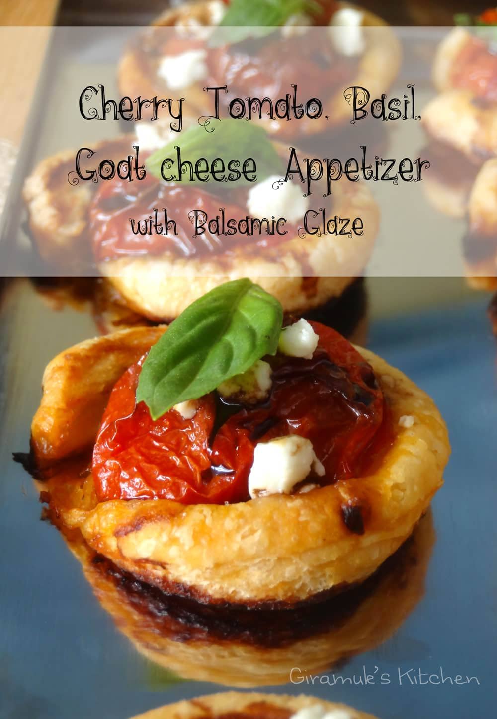 Puff pastry tomato tartlet topped with a basil leaf and goat cheese.