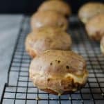 Row of coffee donuts with coffee glaze on a wire rack.