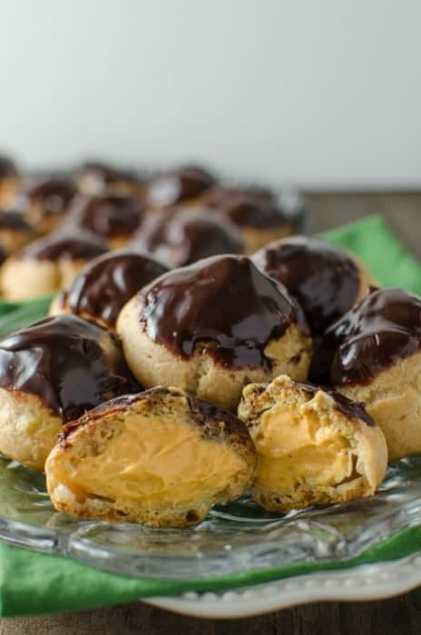 Pumpkin Cheesecake Profiteroles - Bitesized Profiteroles filled with creamy Pumpkin Cheesecake filling and a chocolate glaze. Perfect for Fall and for thanksgiving!