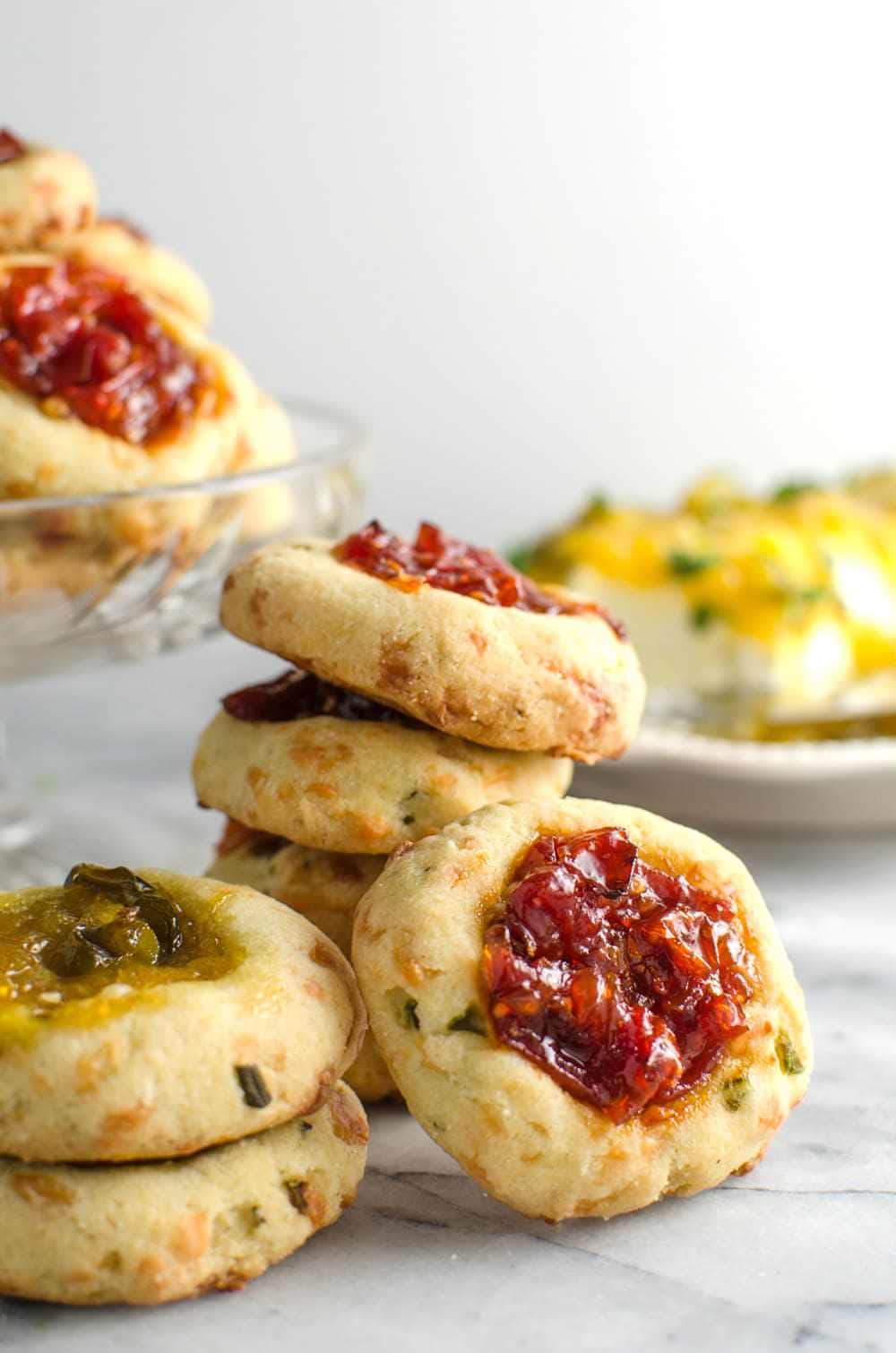 Savory Cheese Thumbprint Cookies with Bourbon Tomato Jam - These savory cookies are the NEXT BEST THING! Buttery, herby cookies with delicious cheddar cheese, and an amazing tomato jam! Comes together easily and its PERFECT as an appetizer, party food, or as a snack!