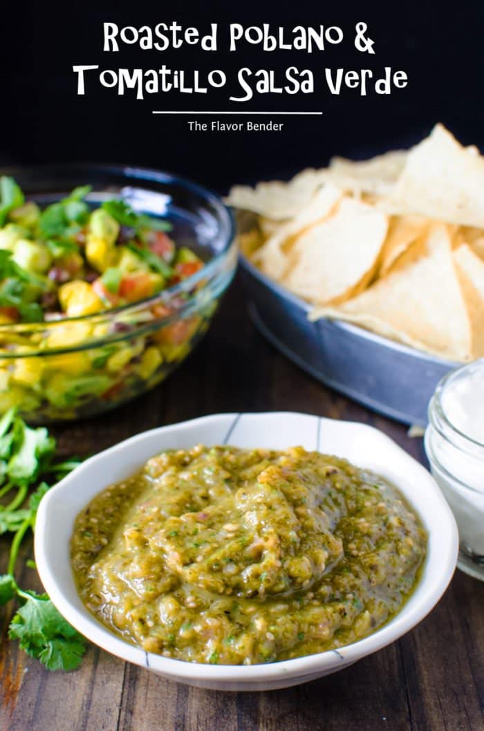 Roasted tomatillo salsa verde served in a small bowl with corn chips in the background