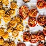Roasted yellow and red cherry tomato halves on a parchment paper.