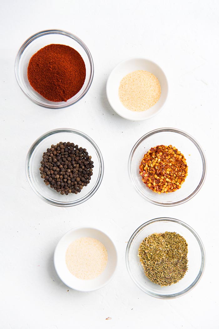 Spices that are used to make Homemade Cajun seasoning, in separate bowls. 