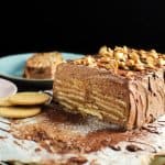 Chocolate biscuit pudding sliced in half to show layers of Maria cookies and chocolate buttercream in the cake.
