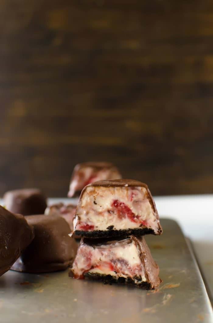 Frozen Jalapeno Strawberry Cheesecake Bites - A rich, creamy cheesecake center, swirled with fresh strawberries and a delectable strawberry jalapeno spread, with an oreo cookie base and then covered in a chocolate shell - these Frozen Strawberry Cheesecake Bites are an easy, addictive snack, perfect for summer and for parties! 