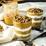 Pumpkin chia pudding with Greek yogurt in a glass, served with chopped pecans on top.