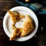 Two puff pastry French onion pies on a white plate, with one broken in half.