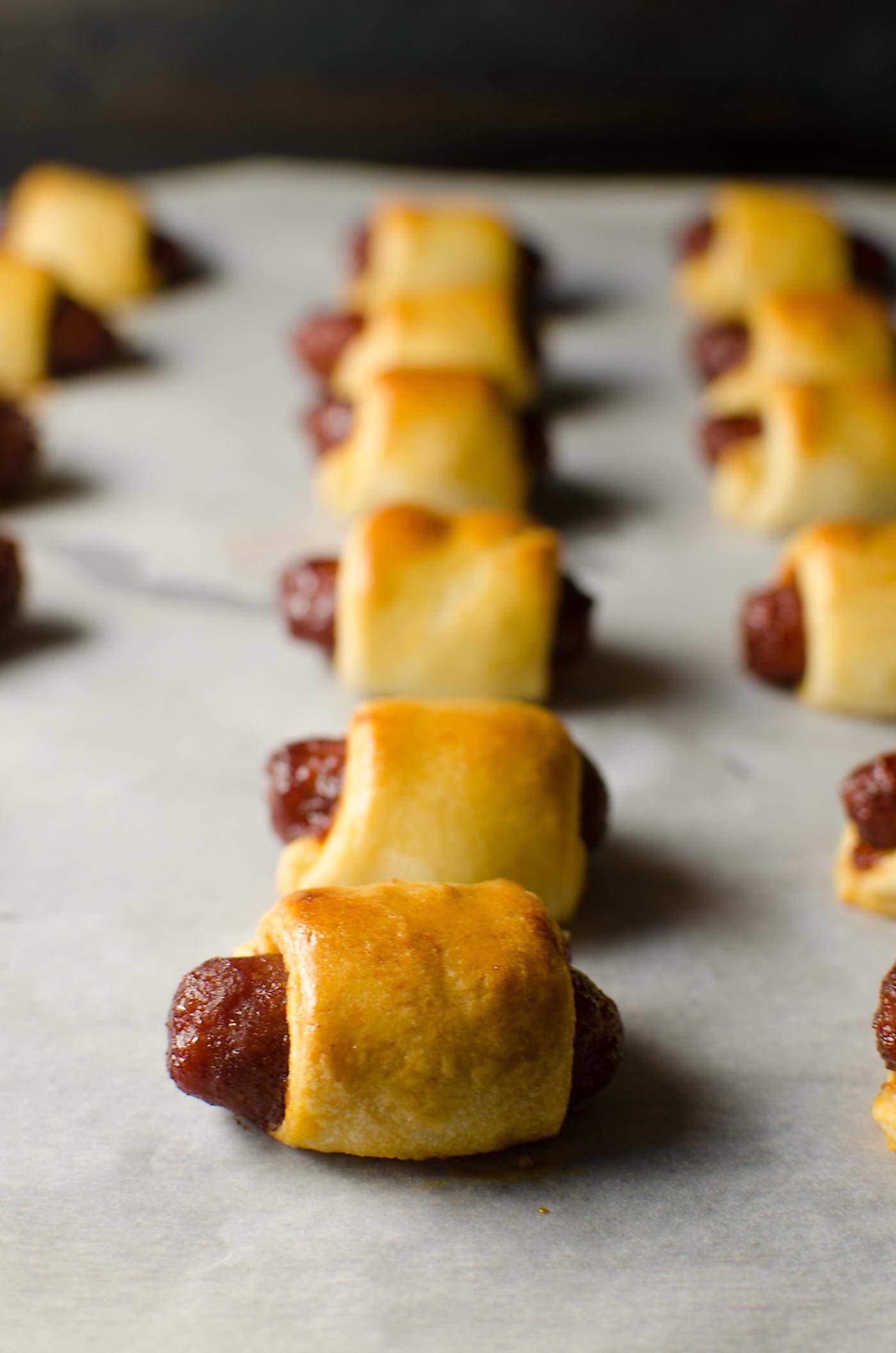 Sweet and Spicy Pigs in a Blanket - Kick up your regular Pigs in a Blanket with this sweet and spicy version served with a creamy spicy cheese sauce, spiced with Habanero and Mustard. Perfect for Holiday Parties, Game day snacks, March Madness or any party! Party food | Appetizers | Pigs in a Blanket | Crescent dough | Nacho Sauce | Cheese Sauce | Game Day | March Madness | Holiday Appetizers