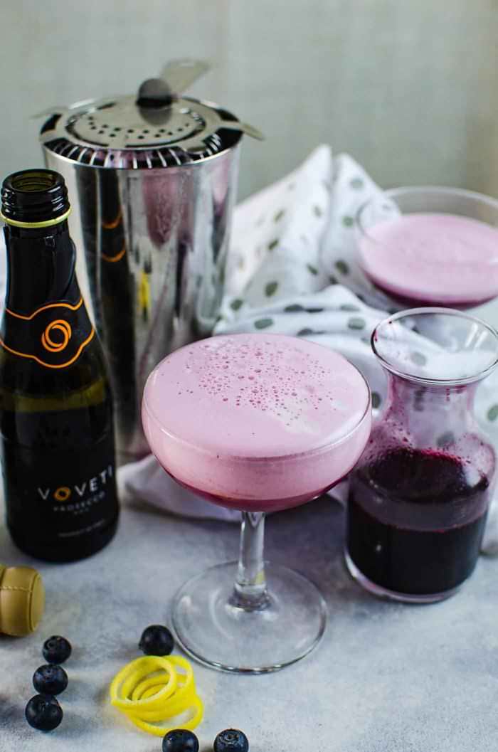 Sparkling Blueberry elderflower sour - This prosecco cocktail is a cross between a mimosa, and a whiskey sour. A gorgeous fruity and floral bubbly cocktail that is perfect for celebrations!