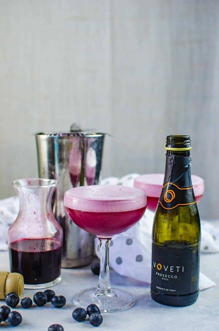 Sparkling Blueberry elderflower sour - This prosecco cocktail is a cross between a mimosa, and a whiskey sour. A gorgeous fruity and floral bubbly cocktail that is perfect for celebrations! Extra foamy and bubbly.