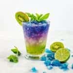 Color changing kiwi lime and mint julep with lime slices and mint leaves next to it.
