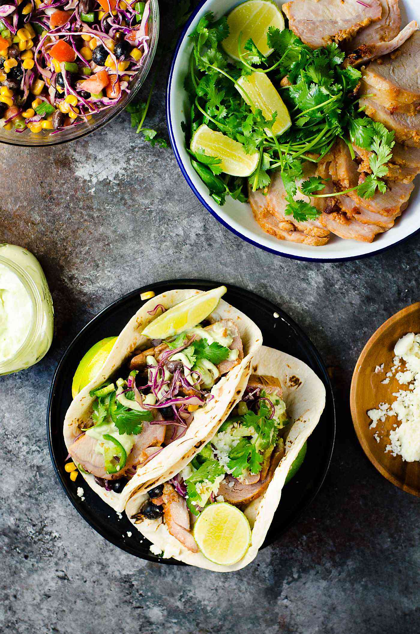 Roasted Pork Tacos  with blueberry coleslaw - Tacos with tender pieces of roasted applewood smoked bacon Pork loin, and topped witha a fresh and light blueberry rainbow coleslaw with an almond honey mustard dressing (no mayonnaise), and an Jalapeno avocado crema. A meal that's ready in 30 minutes with some life saving shortcuts!