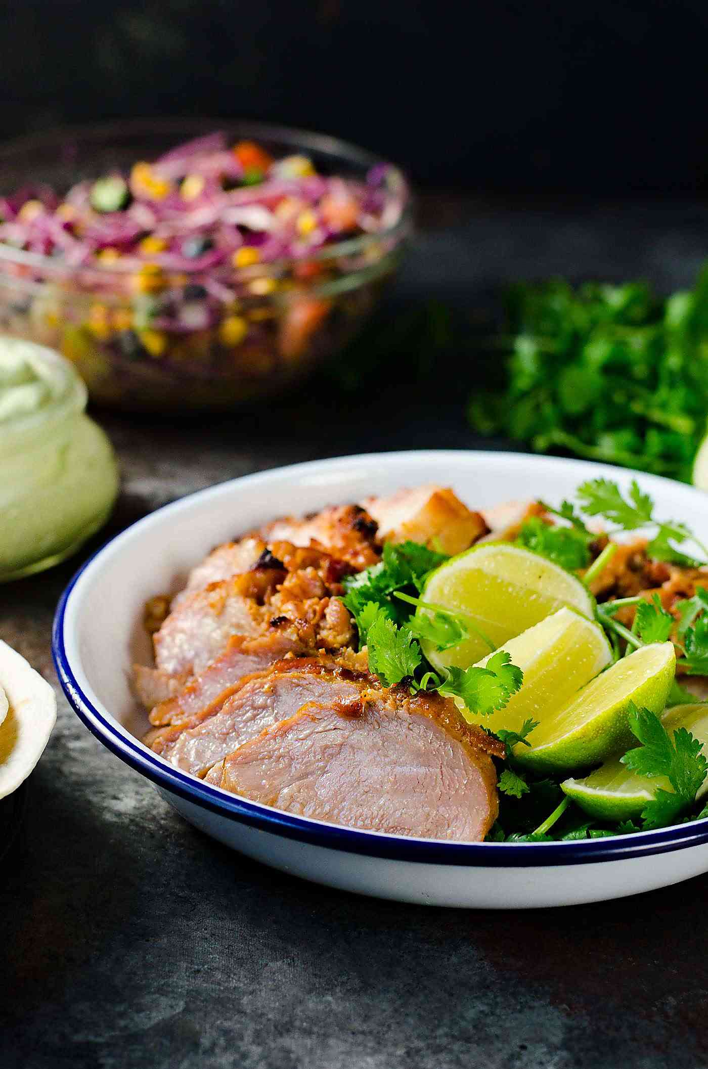 Roasted Pork Tacos  with blueberry coleslaw - Tacos with tender pieces of roasted applewood smoked bacon Pork loin, and topped witha a fresh and light blueberry rainbow coleslaw with an almond honey mustard dressing (no mayonnaise), and an Jalapeno avocado crema. A meal that's ready in 30 minutes with some life saving shortcuts!