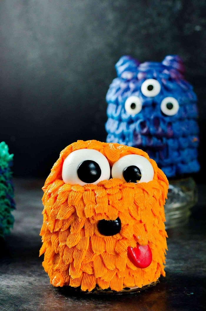 Orange Pet monster - Mini Monster Cakes (Halloween Cakes) - A cake recipe for fudgy Chocolate Sheet cake and a full step by step tutorial to make 5 mini monster cakes that are perfect for Halloween Parties or Monster themed parties. 