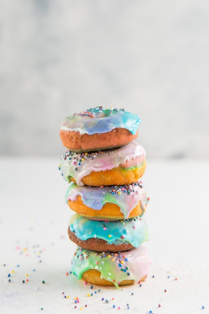 Mini Unicorn Rainbow Donuts with a unicorn Glaze- Colorful and gorgeousfried donuts made with rainbow colored dough and coated with a rippled unicorn glaze. 