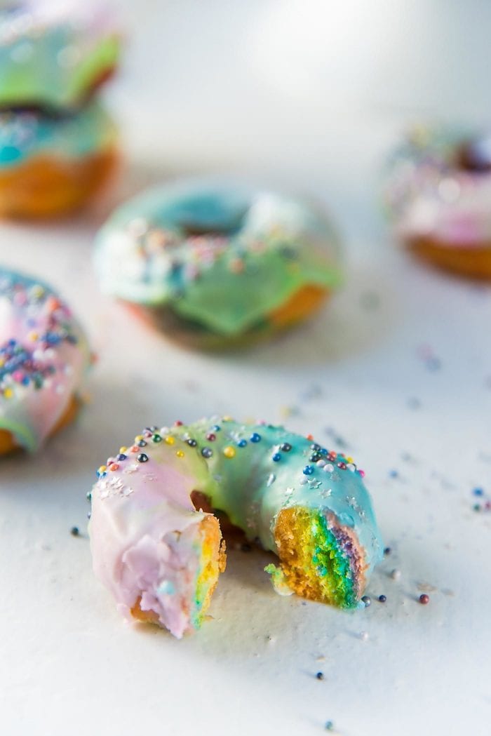 Mini Rainbow Donuts with a unicorn Glaze- Colorful and gorgeousfried donuts made with rainbow colored dough and coated with a rippled unicorn glaze. 