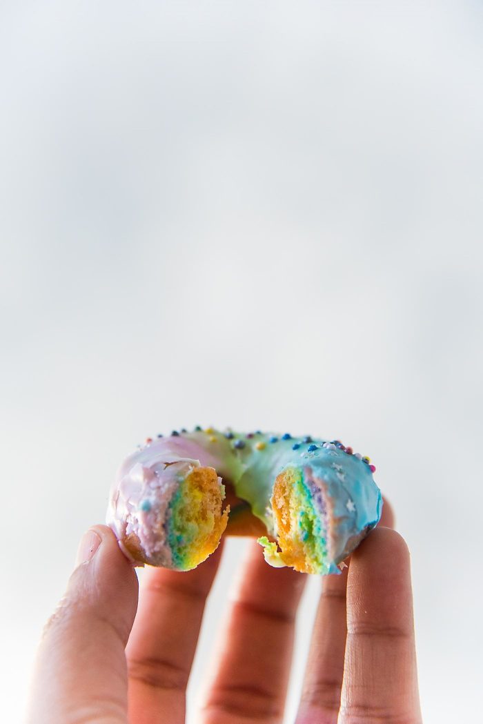 Mini Rainbow Donuts with a unicorn Glaze- Colorful and gorgeousfried donuts made with rainbow colored dough and coated with a rippled unicorn glaze. 