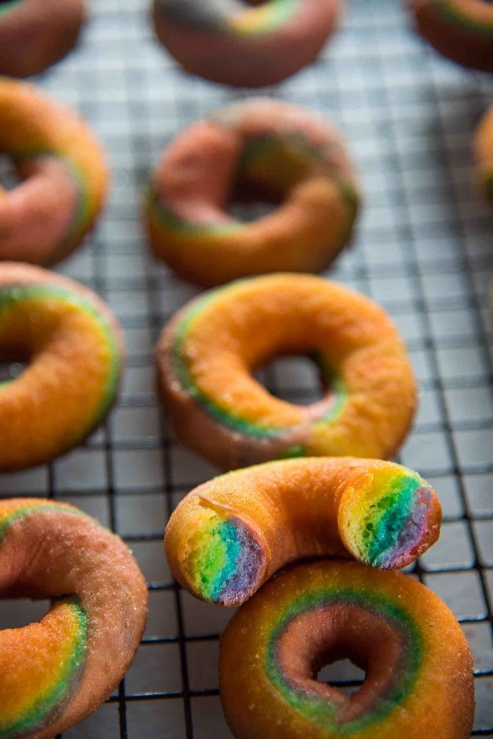 Mini Rainbow Donuts with a unicorn Glaze- Colorful and gorgeousfried donuts made with rainbow colored dough and coated with a rippled unicorn glaze. 