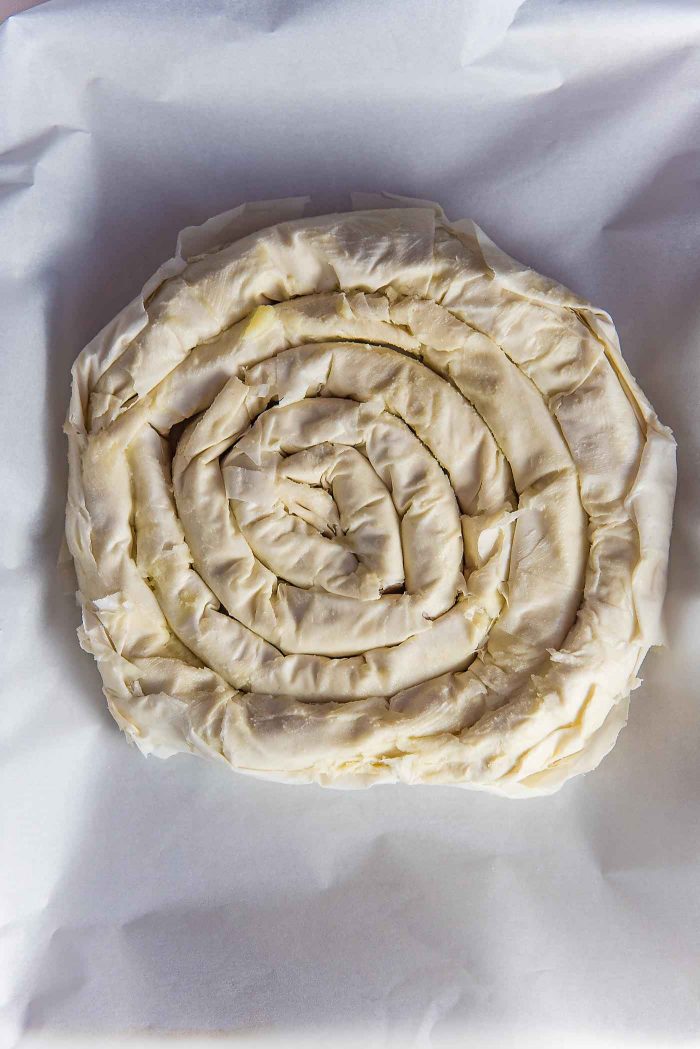 Citrus, Date and Almond M'hencha - The flaky filo snake is wrapped around to create a coiled pastry cake. Brush with butter and/or eggs before baking.