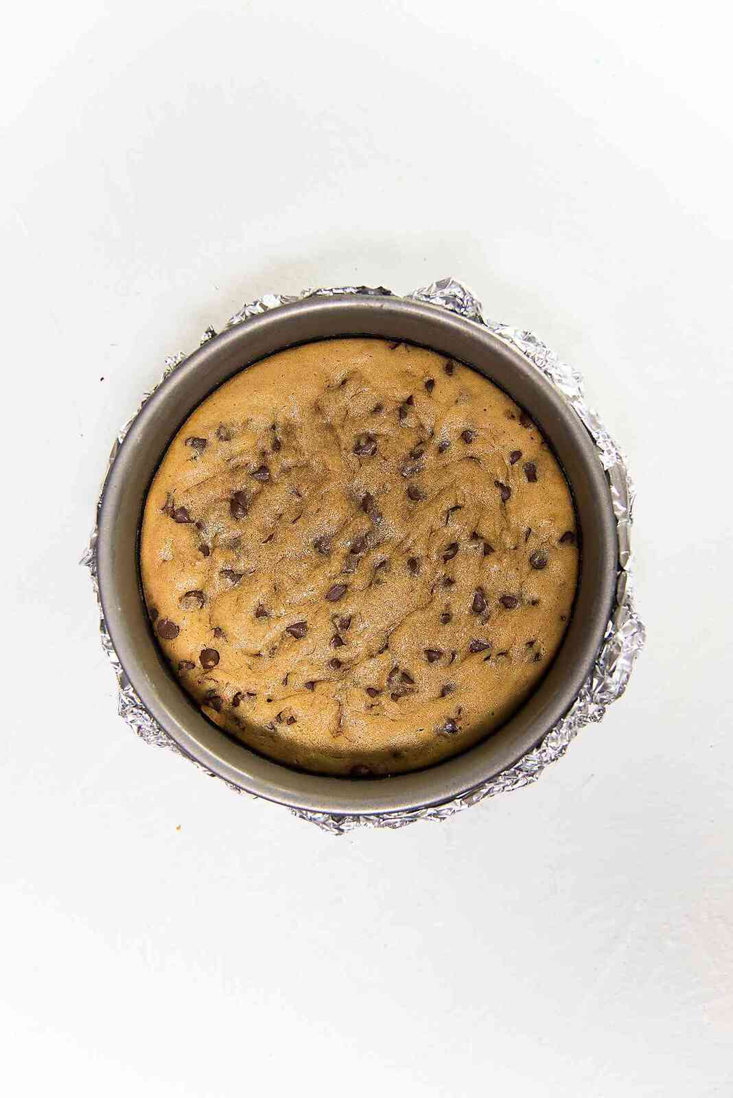 Cookie Monster Cheesecake - The chocolate chip cookie blondie is par baked before adding the cream cheese layer. The cookie layer needs to be fudgy, so make sure not to over bake it..