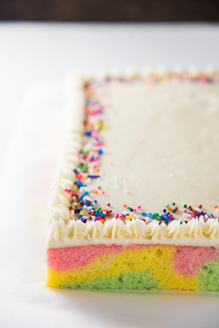 Ribbon Cake (Swirled Pastel Sheet Cake) - A simple vanilla frosting topping this cake with a border, is a classic way to serve this Sri Lankan Ribbon Cake. 