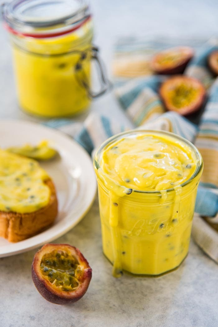 A thick and luscious spread that is tangy, and fruity - Passion fruit curd can be stored in a glass jar with a spoon rested on top. Made with fresh passion fruit, that has been kept near the jar. 