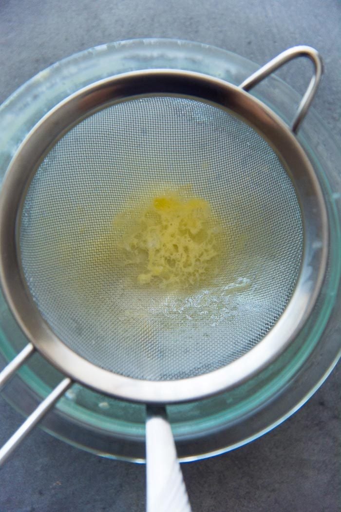 Eggs whisked with a fork and passed through a sieve, leaves bits of egg whites in the sieve.