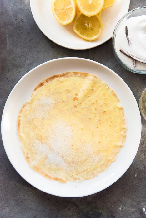 Step 2 for making lemon and sugar crepes - Sprinkle the sugar on one half of the crepe.