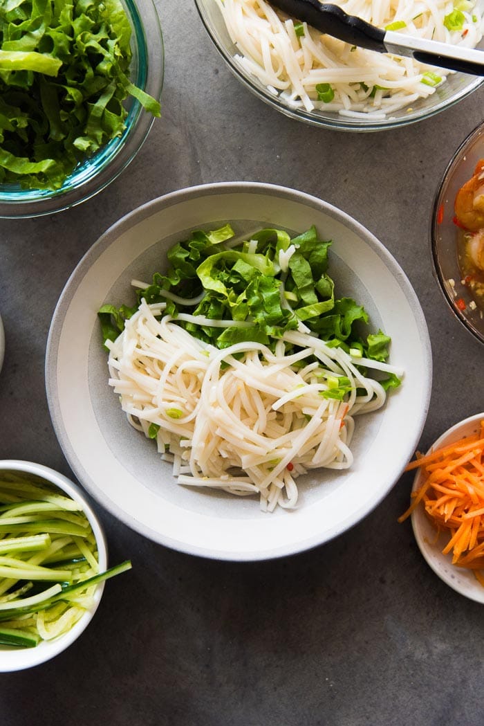 Assembling Garlic Lime Shrimp Rice noodle salad. Top the lettuce with the rice noodles.