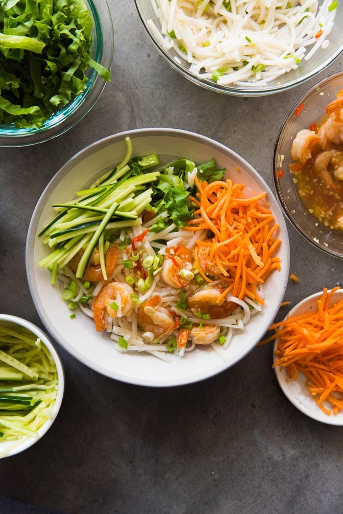 Assembling Garlic Lime Shrimp Rice noodle salad. Add the julienne carrots.