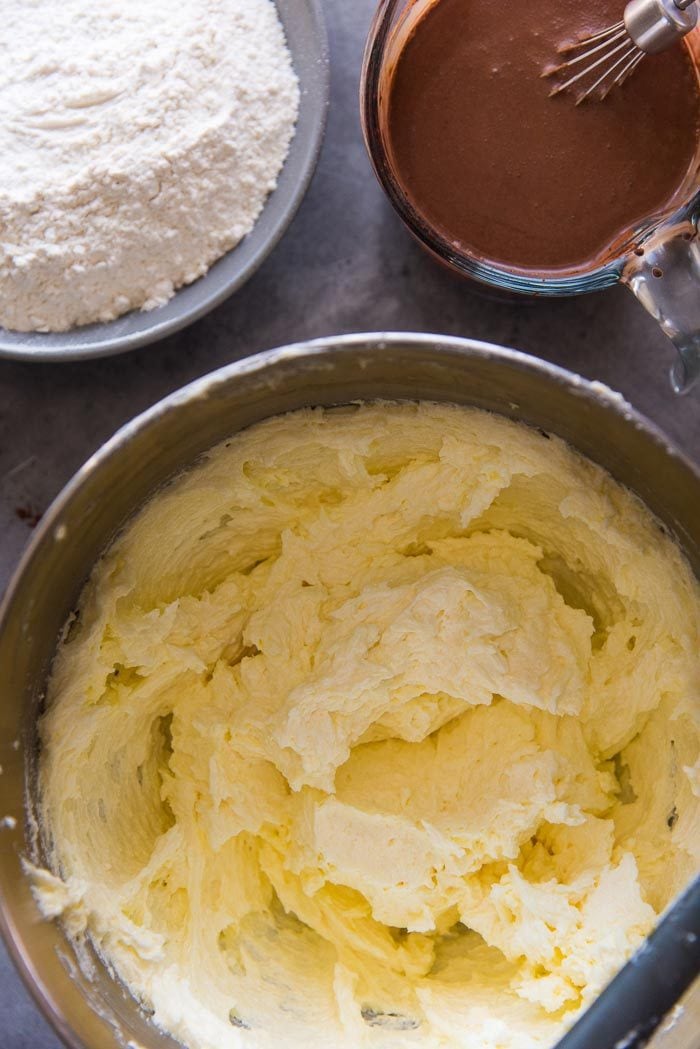The butter and sugar has been creamed together in the mixing bowl, with the chocolate milk in a jug, and the sifted flour in another bowl in the background - ready to be added into the batter.