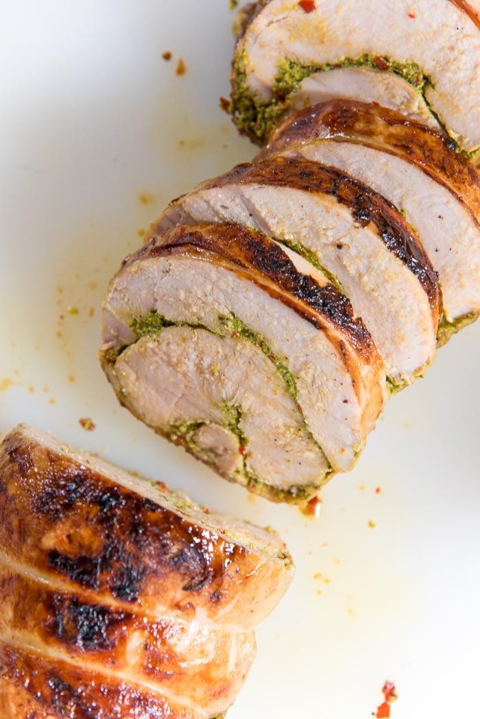 An overhead view of the Sous vide turkey roulade cut into slices on a white board.