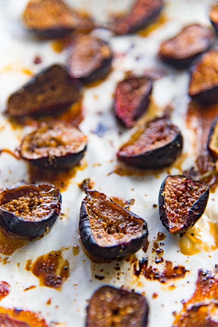 Roasted figs out of the oven, on a parchment paper lined baking tray.