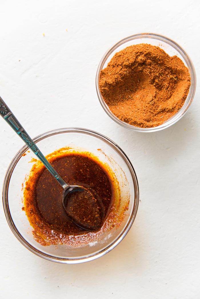 Cajun spice mix in a small bowl, with the cajun spice paste for the turkey breast roast in a separate bowl.