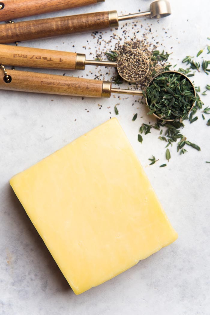 Some of the ingredients to make slice and bake cheddar cheese cookies - cheddar cheese, thyme and black pepper. 