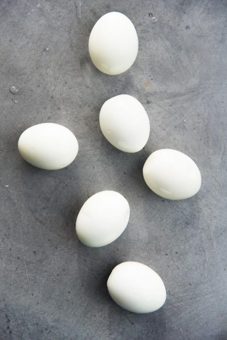 Soft boiled eggs places on a grey table top