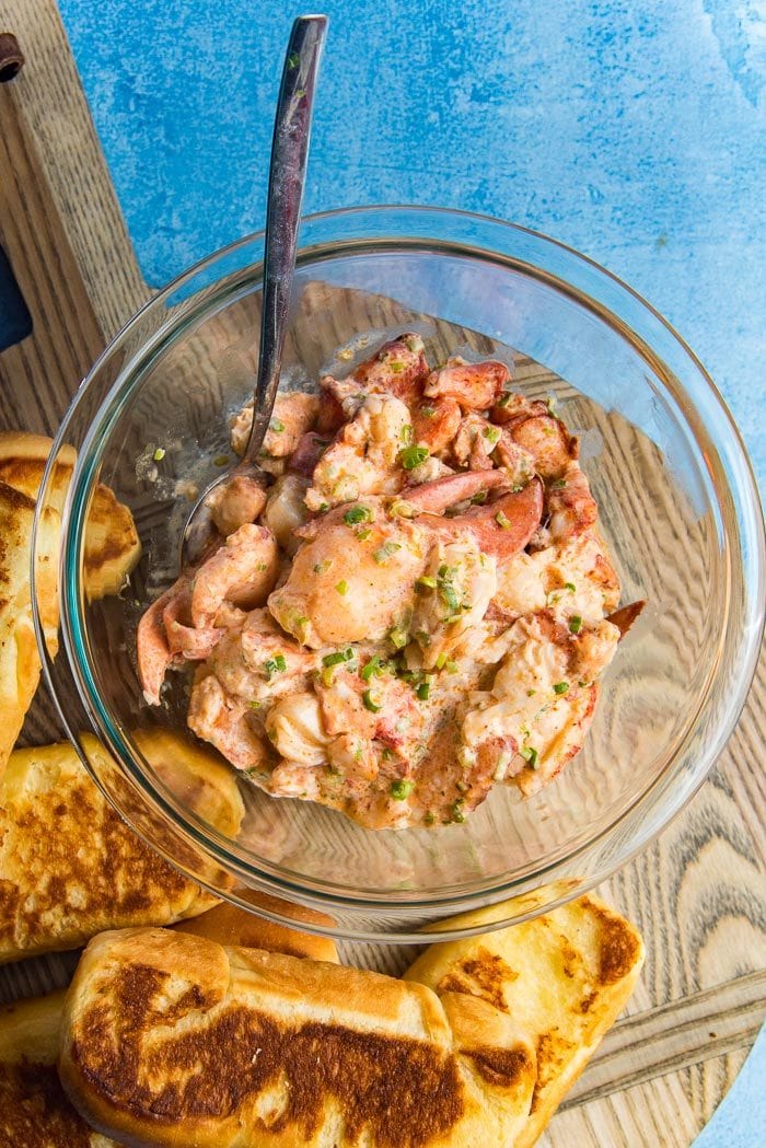 Maine Lobster roll recipe includes lobster salad mixed with mayonnaise, that is placed in this glass bowl. 
