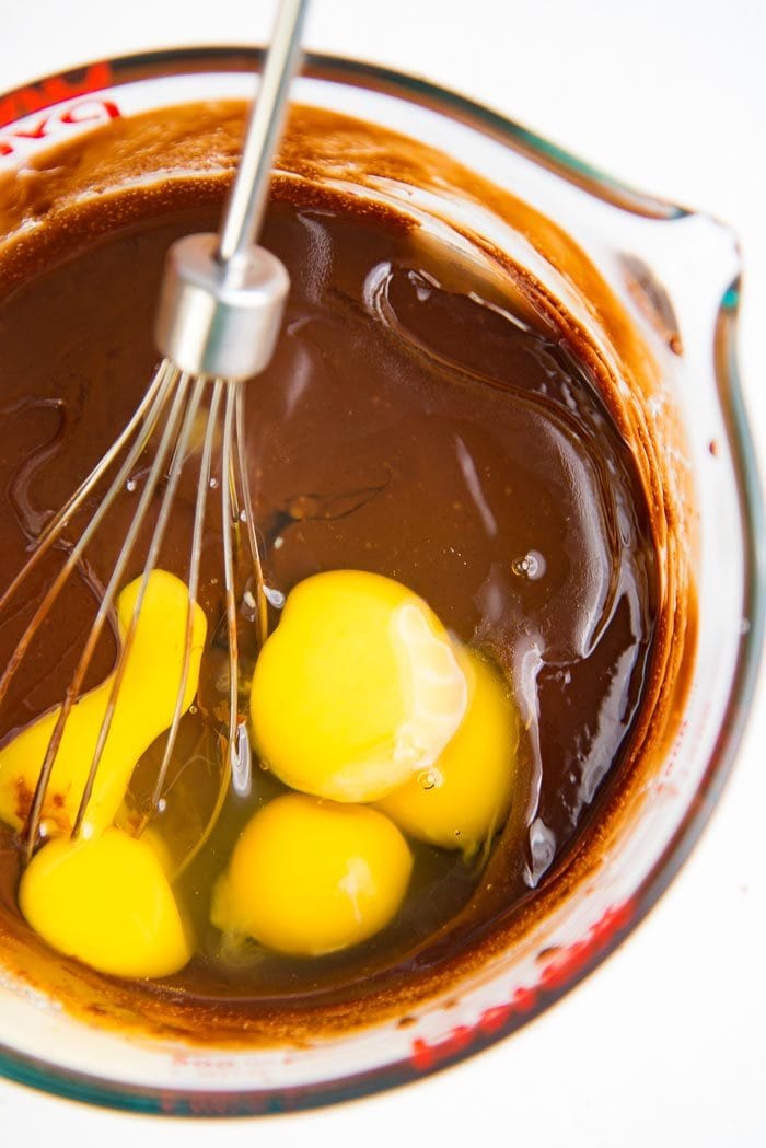 Process for the chocolate molten cake recipe - Eggs add to the butter chocolate mix in a glass pyrex bowl.