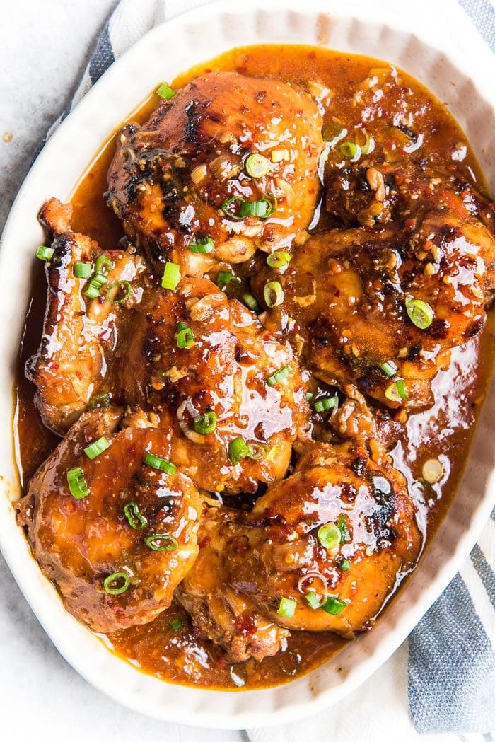 Sauce glazed honey soy chicken thighs made in an instant pot, in a serving platter with the sauce on top.