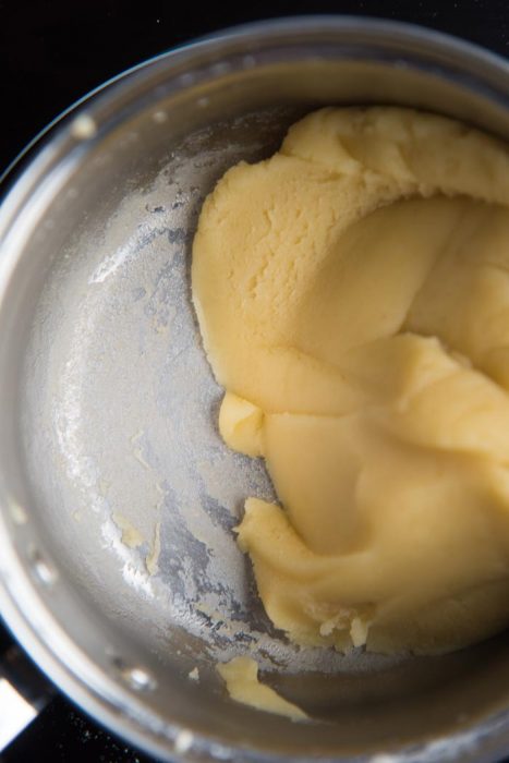 Step by step classic eclair recipe - Stir and mix the dough until the dough comes together to form a ball, and a film of dough forms at the bottom of the pot