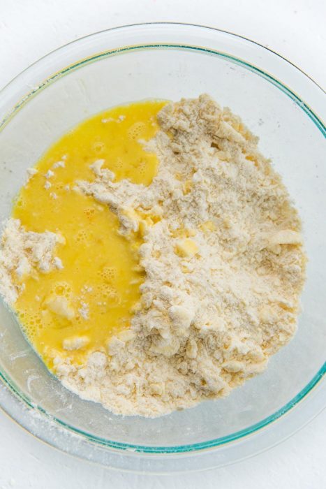 How to make a quiche crust - Beaten egg and water being mixed into the butter and flour