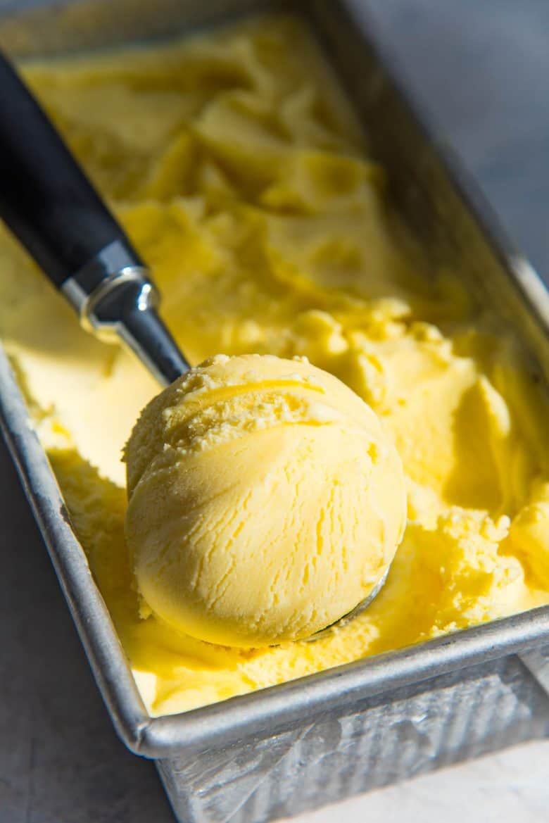 A scoop of lemon ice cream in the container to show texture