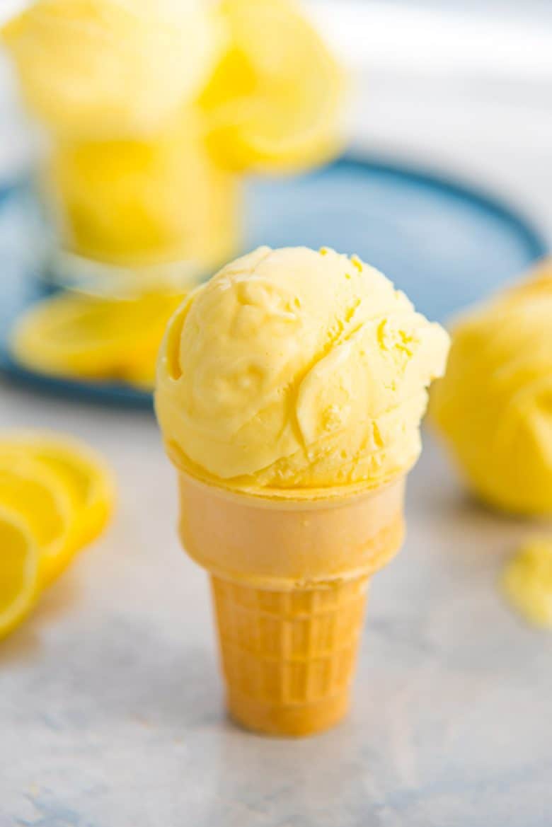 Creamy lemon ice cream made with lemon curd scooped in an ice cream cone