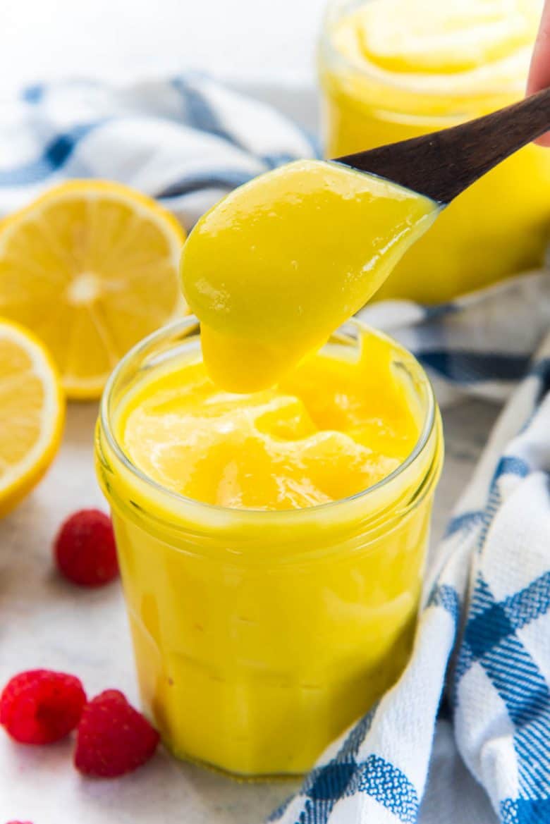 Luscious lemon curd in jar, with a spoonful of lemon curd above the jar
