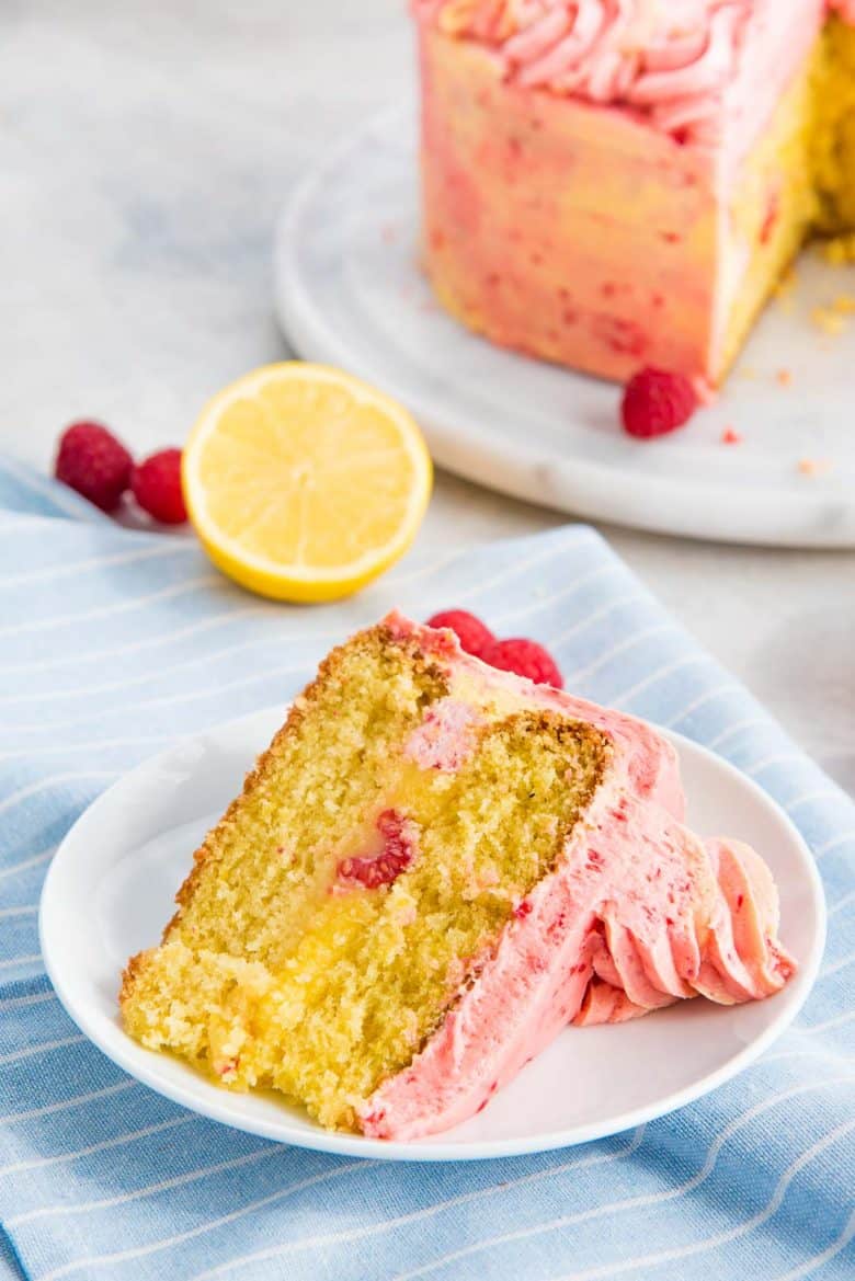 Lemon raspberry cake slice with lemon curd filling on a white plate