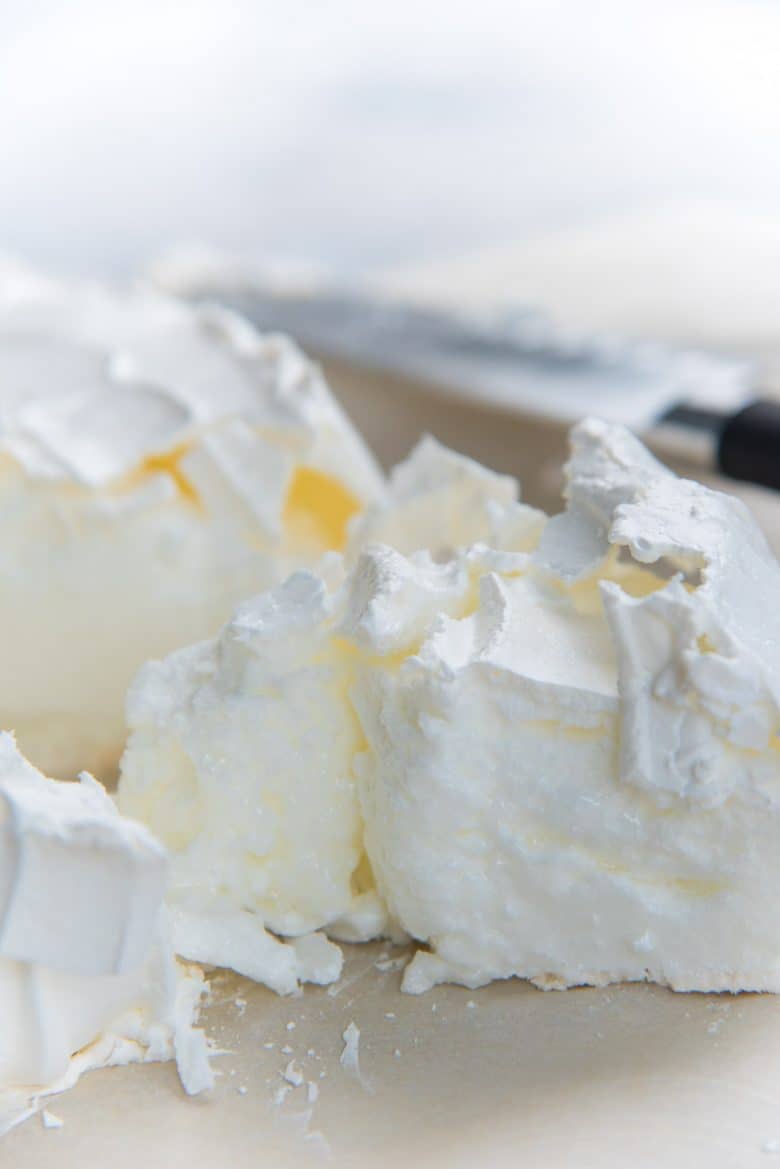 A weeping pavlova, showing the wet marshmallow center.