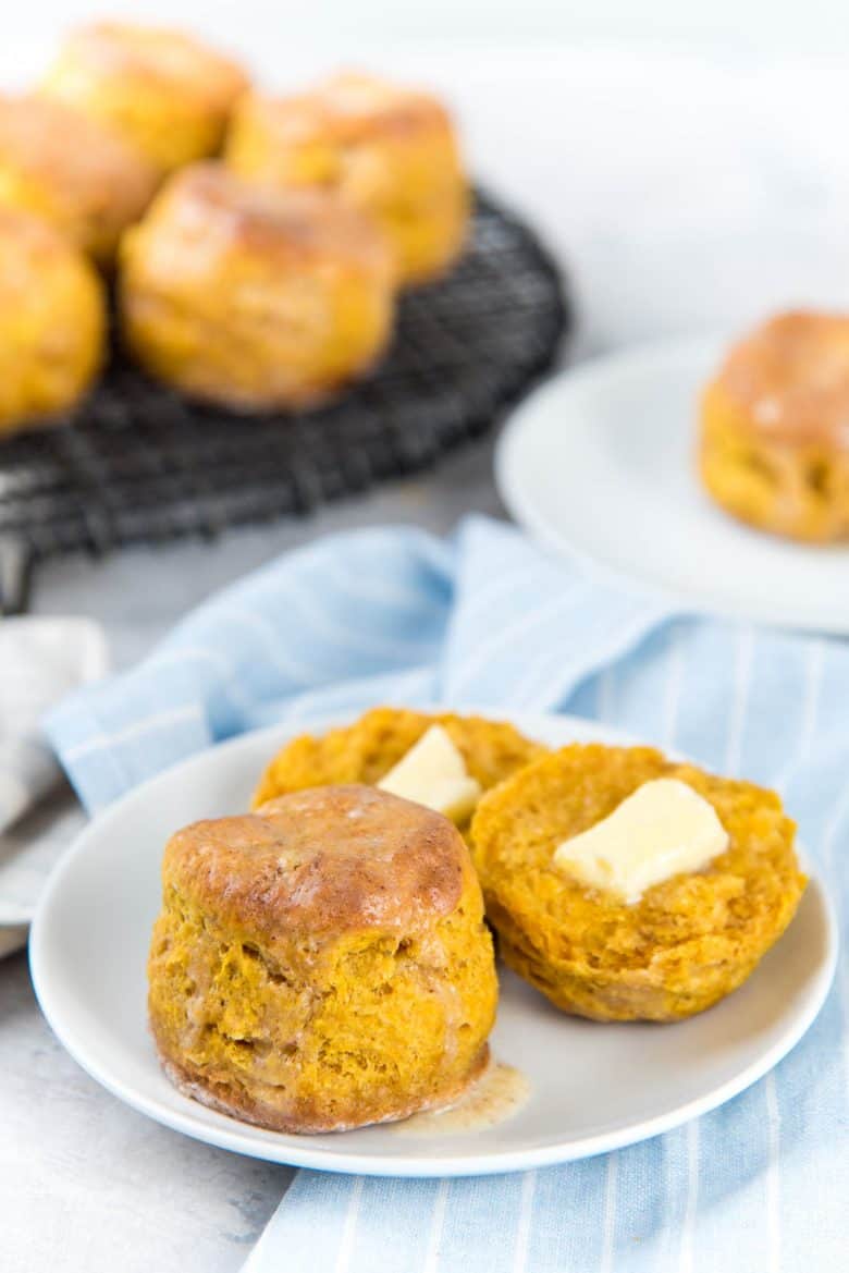 Classic pumpkin scones on a white plate, with one split in half
