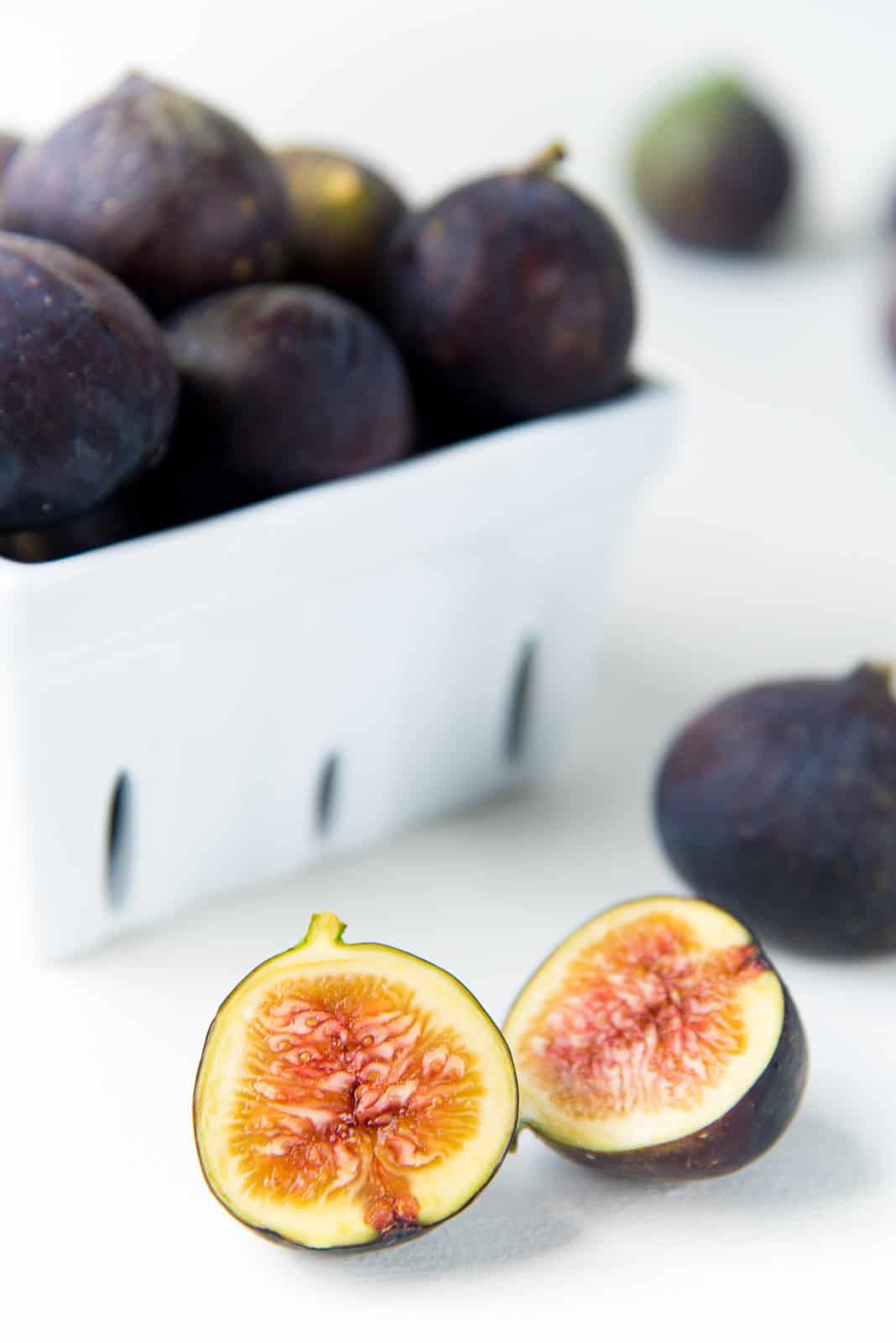 Fresh fig halved with fresh figs in the background