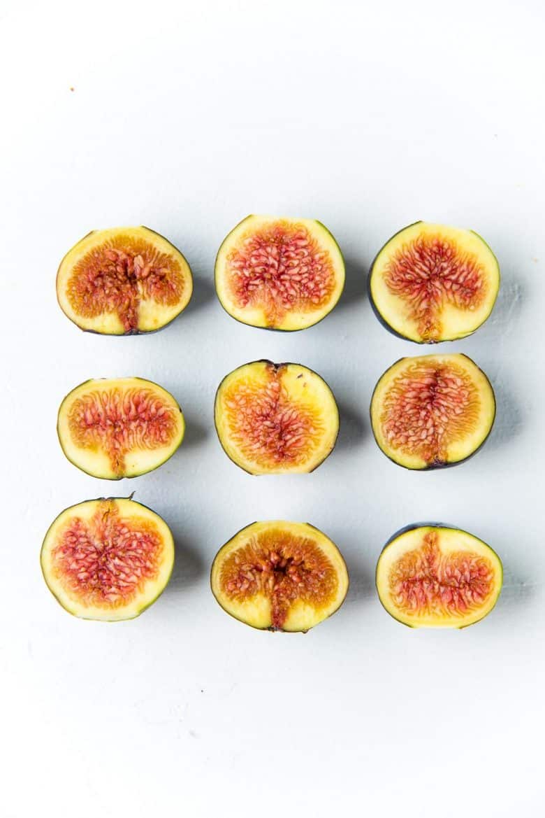 Halved fresh figs on a white background