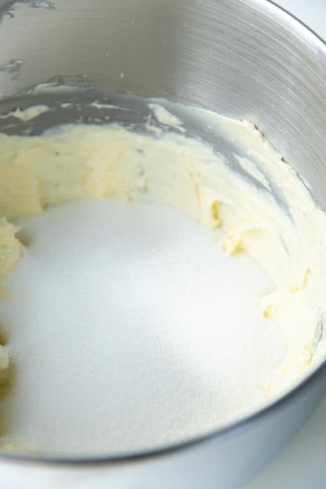 Butter and sugar being creamed in a mixing bowl